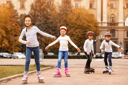 快乐的孩子在城市街道上轮滑