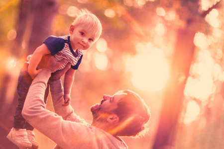 快乐的爸爸在户外玩耍时把孩子扔了照片