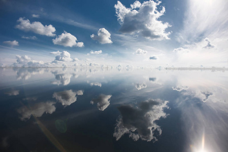 美丽的天空，云彩反映在平静的水面。天空在地平线上水与合并