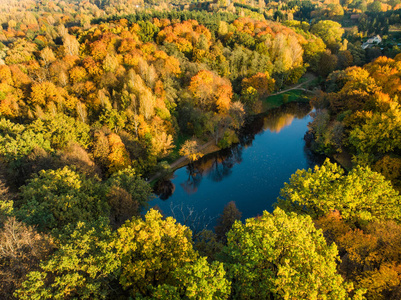 鸟瞰森林和一个小湖。秋天的空中五颜六色的森林场景与橙色和黄色的叶子。在立陶宛维尔纽斯附近的秋季风景