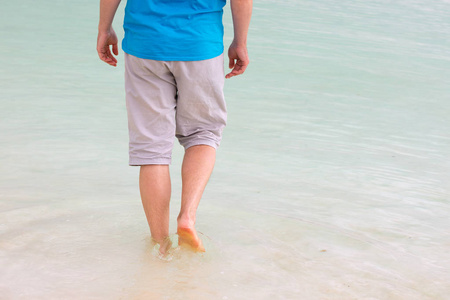 一个人赤脚走在死海的咸水海滩上照片