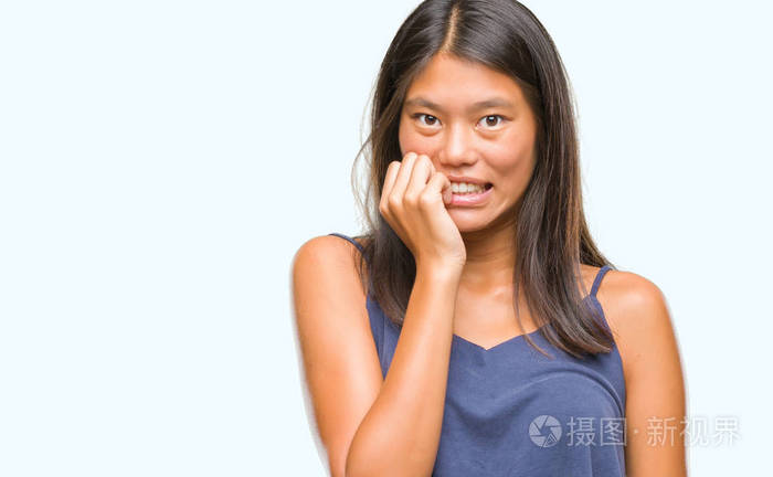 年轻的亚洲妇女在孤立的背景下, 看着压力和紧张的嘴咬指甲的手.