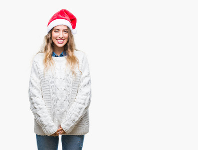 美丽的年轻金发女子戴着圣诞节帽子在孤立的背景与一个愉快和凉爽的笑容在脸上。幸运的人