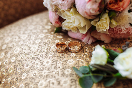 美丽的婚礼花束, 两个金戒指, 布顿尼埃, 躺在扶手椅上, 婚礼的日子。重要的节日配件
