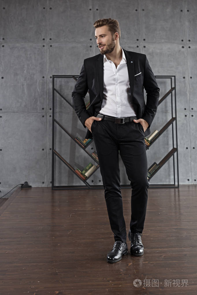 一个穿着黑色西装的帅哥在手机上的商务谈话