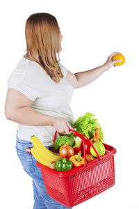肥胖的女人抱着鲜橙色图片