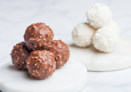 豪华巧克力糖果与子和白色奶油与椰子片圆形糖果在大理石背景