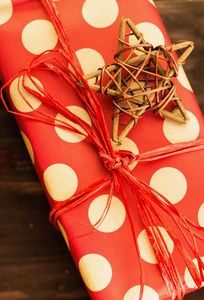 圣诞节和元旦节日装饰, 木星与礼物包裹着红色的纸与金色的圆圈在棕色木头背景。平躺着。从上面看。复制文本的空间