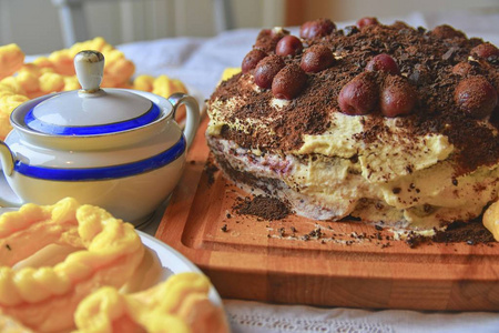 巧克力蛋糕配樱桃磨碎的巧克力和奶油。在节日的桌子上自制奶油泡芙。复古糖碗。特写。厨房背景