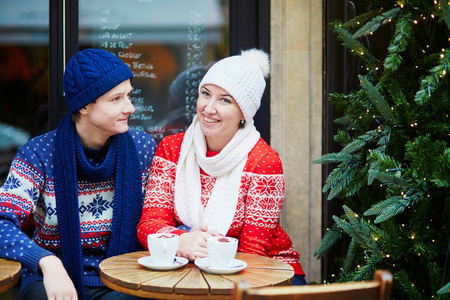幸福夫妇喝咖啡在巴黎户外咖啡馆装饰圣诞节