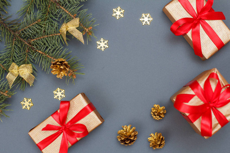 圣诞装饰。礼品盒, 杉木树枝与锥在灰色背景。顶部视图。圣诞贺卡概念