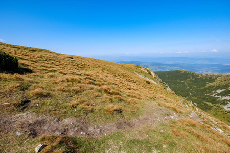 秋天, 斯洛伐克塔特拉西部喀尔巴泰的岩石山顶上有徒步小道, 山上有蓝天和晚草。在明亮的日光下空岩, 冒险的遥远地平线
