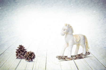 圣诞节装饰老摇摆马和松树锥体在白色冬天木背景与雪花。概念假日象征圣诞快乐, 新年