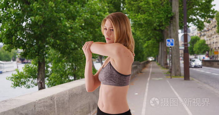 运动健康的白种人妇女在早晨跑步前在户外伸展运动