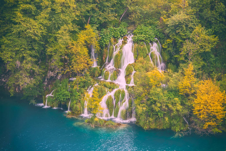 秋天在普利特维采湖国家公园, 瀑布在五颜六色的森林, 克罗地亚。自然背景适合墙纸封面或导游