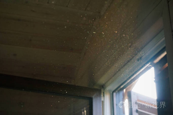 一缕阳光穿过木百叶窗, 照亮了黑暗房间内部的灰尘.特写, 选择性对焦