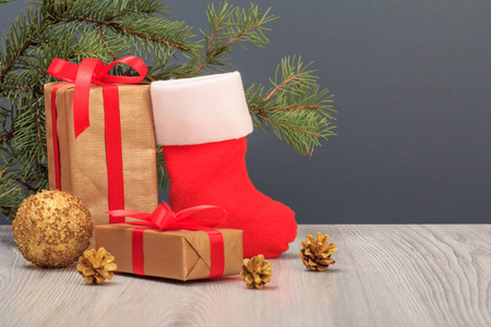 圣诞装饰。礼品盒, 圣诞老人的靴子, 玩具球和冷杉树枝灰色的背景。圣诞贺卡概念
