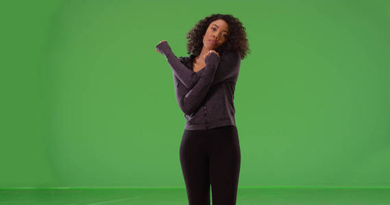 健康的黑人女子运动员伸展手臂在绿色屏幕上的锻炼
