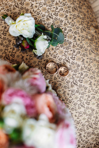 美丽的婚礼花束, 两个金戒指, 布顿尼埃, 躺在扶手椅上, 婚礼的日子。重要的节日配件