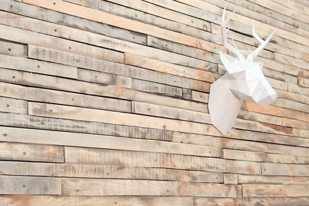 木制板条墙上的鹿头是用纸做的。以某一角度查看。设计背景的装饰在房间里。复制空间。圣诞墙面装饰