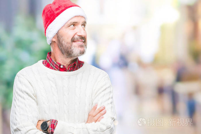 中年苍老的老人戴着圣诞帽在孤立的背景下, 脸上露出笑容, 自然的表情。笑的自信