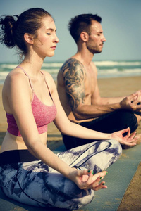 做瑜伽在海滩上的情侣