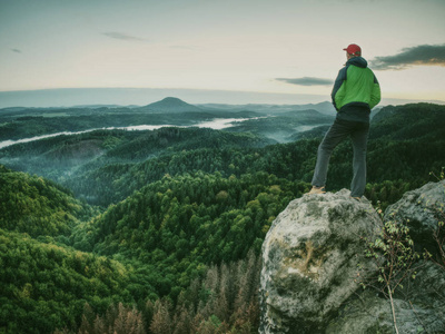 游客在山顶上欣赏雾蒙蒙的乡村美景.旅游生活方式成功冒险照片