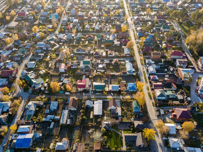 在一个秋季下午在城市郊区的大量小房子的鸟瞰图在印度夏天与道路和汽车