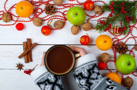圣诞装饰品和一杯咖啡上木制的手