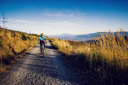 骑自行车的妇女在秋天的山森林风景。骑自行车 mtb 流动小道轨道的妇女。户外运动活动