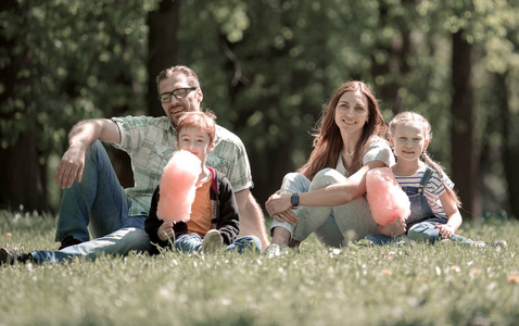 快乐的家庭坐在草坪上的城市公园