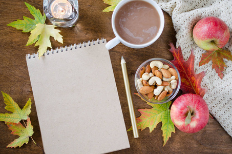 空白棕色笔记本, 带针织毯子一杯热可可和木桌小吃。感恩节的概念。秋天静物。舒适的秋天心情。复制空间