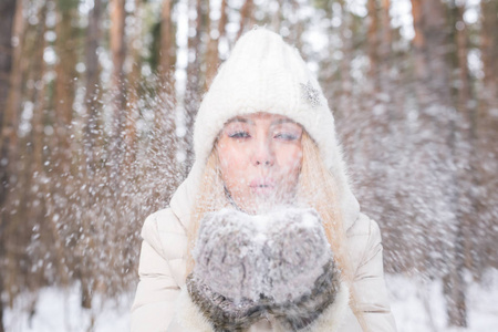 圣诞节, 节日和季节概念年轻快乐的金发女子吹雪在冬季自然