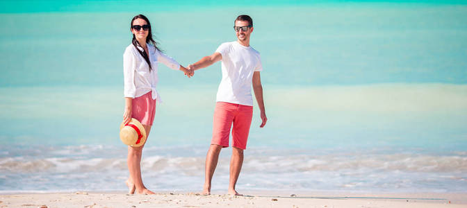 年轻夫妇在白色海滩。蜜月度假快乐家庭