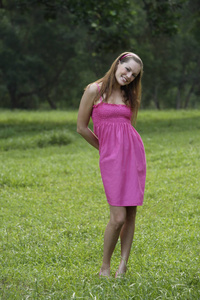 粉红色的裙子站在草地上的女人