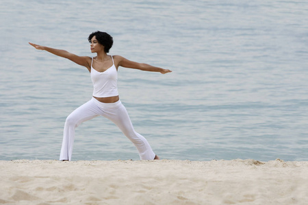 女人在做瑜伽在海滩上