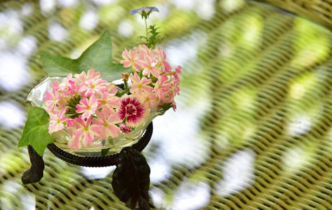 在玻璃桌上放上装饰的绿叶的粉红色花朵和场景