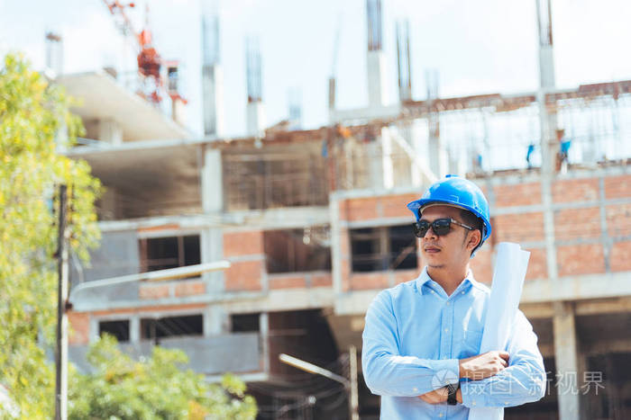 建筑现场使用蓝色安全帽和太阳镜的土木工程师