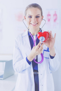 医生用听诊器检查红色的心，在白色背景上孤立