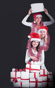 三年轻女孩在圣诞老人服装显示空白的板料