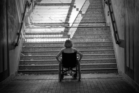 轮椅上的妇女站在楼梯前寻找帮助