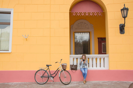 年轻女子自行车骑手使用手机, 城市背景