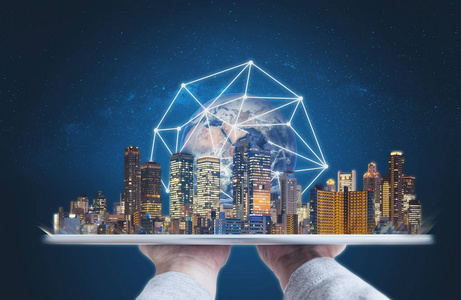 手持数字平板电脑与现代建筑全球网络连接技术全息图.