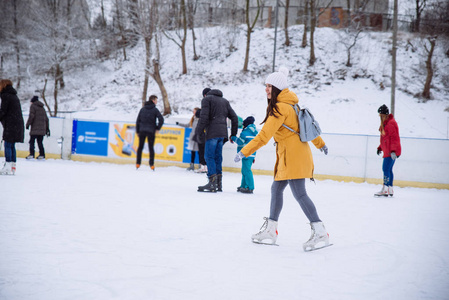 年轻女子学习滑雪在城市溜冰场