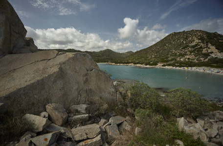 由一个大岩石过滤的天然海湾 撒丁岛南部海岸的典型看法