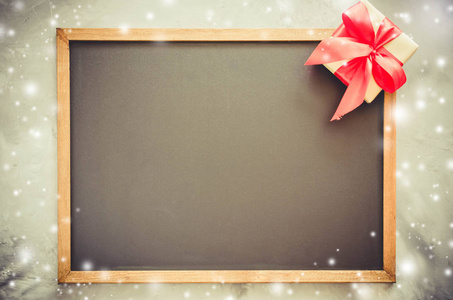 圣诞节背景与黑板, 雪边框和红色礼品盒。色调的图像。复制空间, 雪的效果。圣诞复古黑板