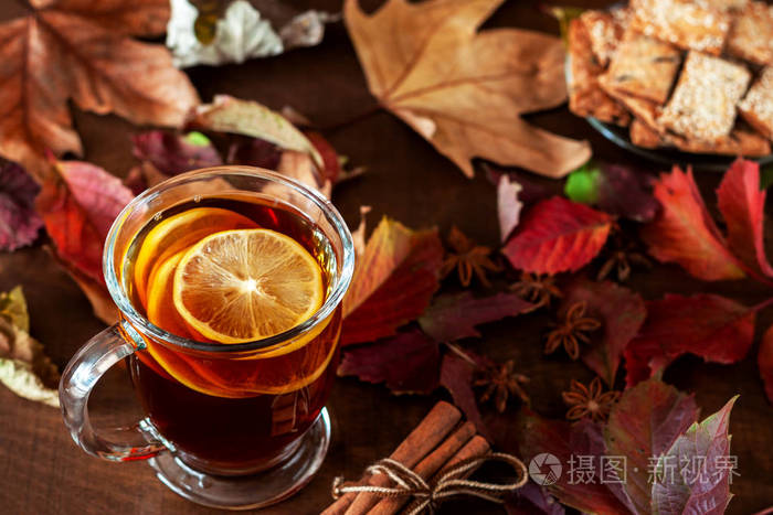 一杯茶站在一张铺满秋叶的桌子上