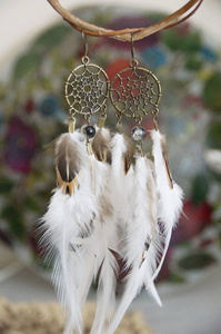 手工制作的耳环在梦想捕手风格与羽毛和青铜配件