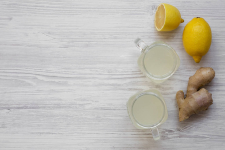 玻璃罐自制姜茶与柠檬在白色木制背景, 头顶的景色。平躺, 从上面, 顶部的看法。复制空间