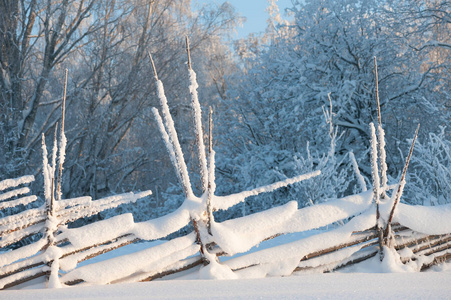 覆盖着积雪的旧木栅栏。芬兰的冬天风景